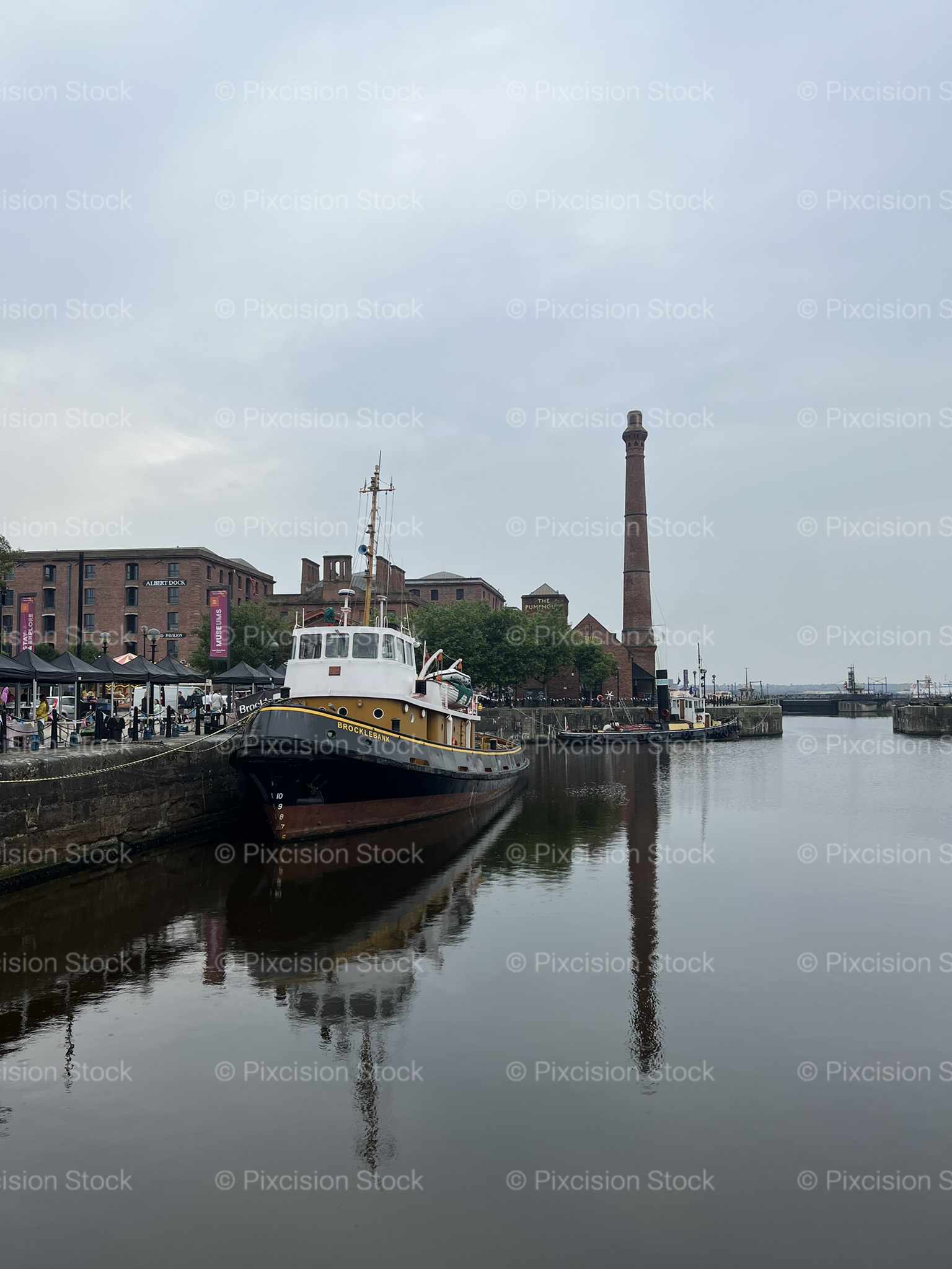 Historic Tugboat Brocklebank Moored at Albert Dock with Victorian Pumphouse Chimney Liverpool England