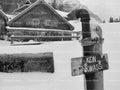 Snow-Dusted Wooden Signpost in Front of a Winter Cabin (Monochrome)