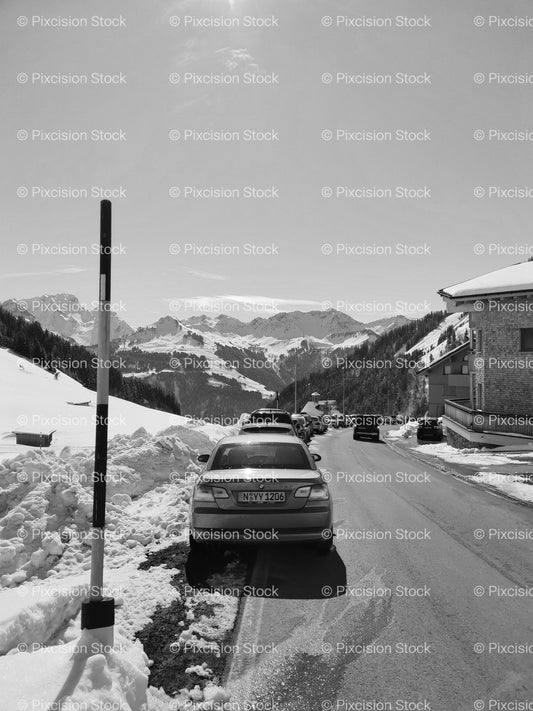 Cars Parked Along a Snowy Mountain Road Bordered by Marker Posts (Monochrome) - Stock Video