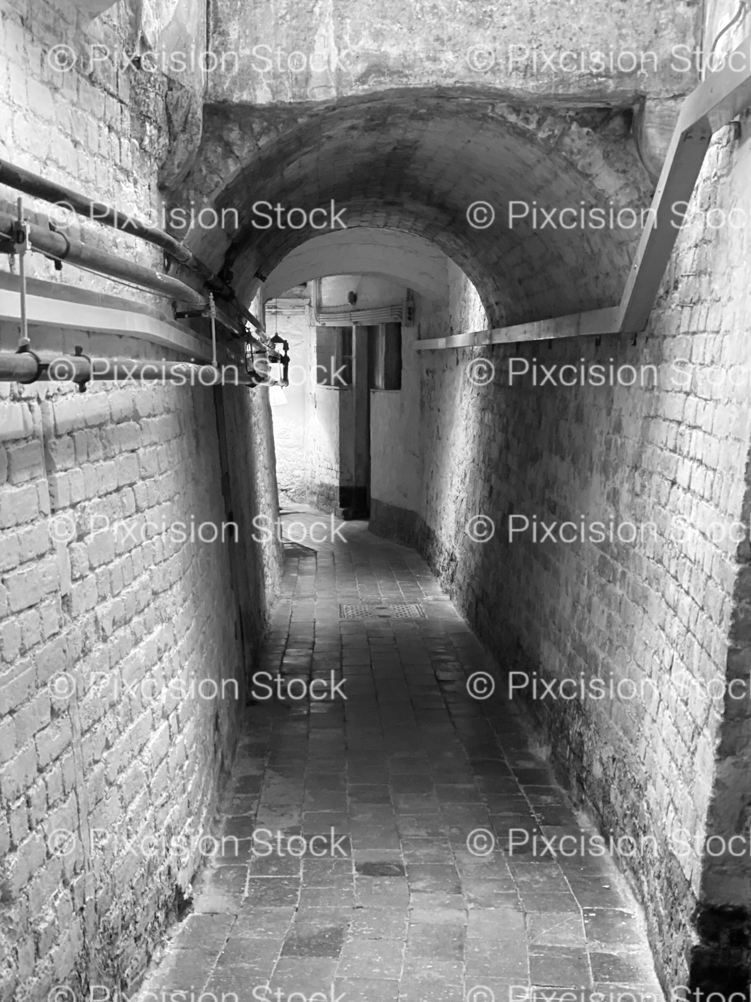 Looking Down a Narrow, Arched Brick Vault or Corridor (Monochrome)