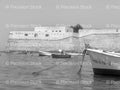 Small Boats Moored Near a Coastal Fortification Wall (Monochrome)