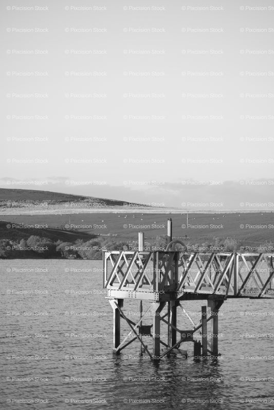 Metal Pier Structure Stretching out into a Calm Body of Water (Monochrome) - Stock Video