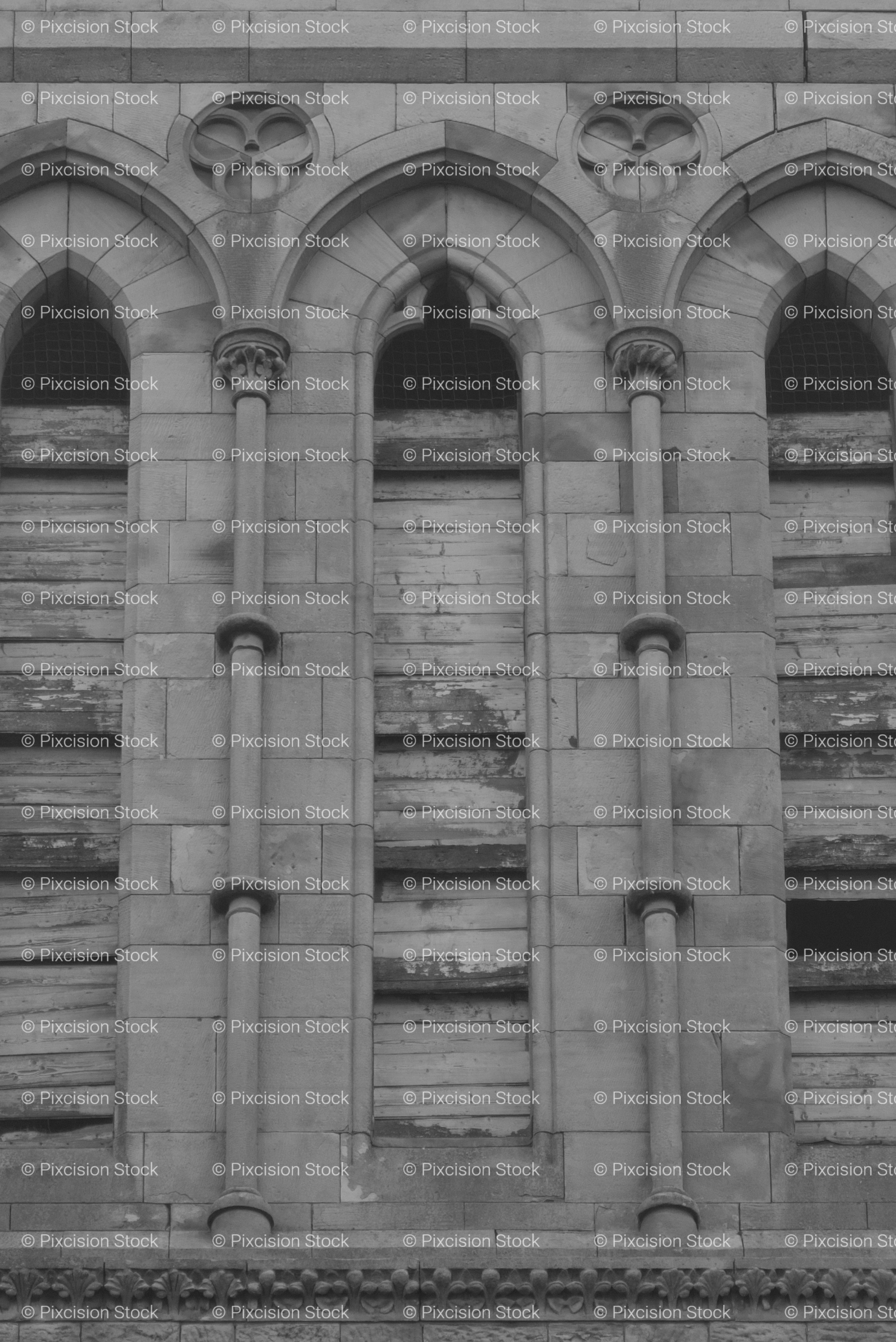Group of Three Narrow Arched Windows on a Historic Stone Wall (Monochrome)