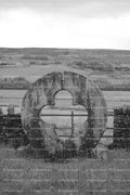Vertical Shot of a Round Stone Wall Opening in a Pasture (Monochrome)