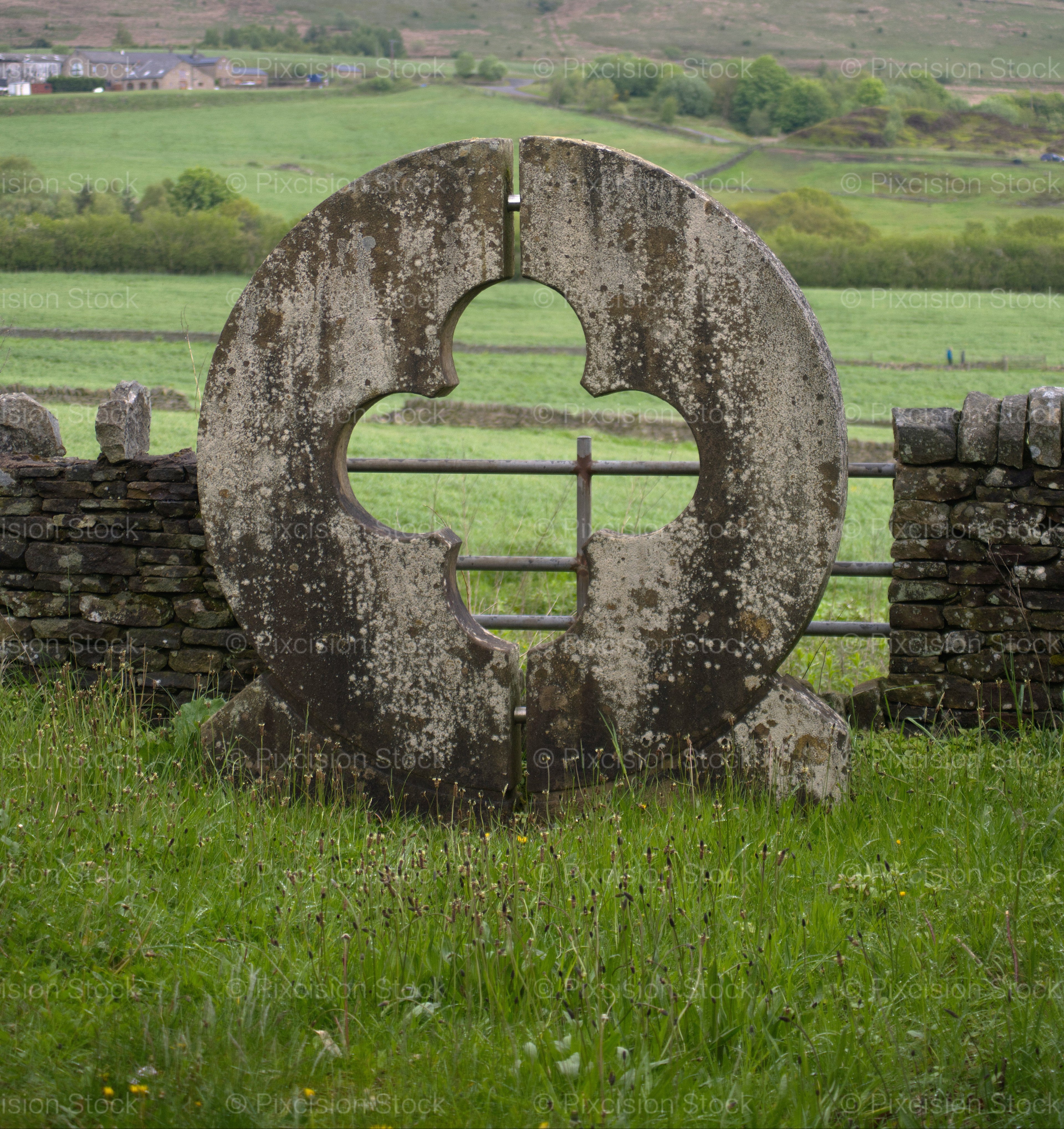Vertical Shot of a Round Stone Wall Opening in a Pasture