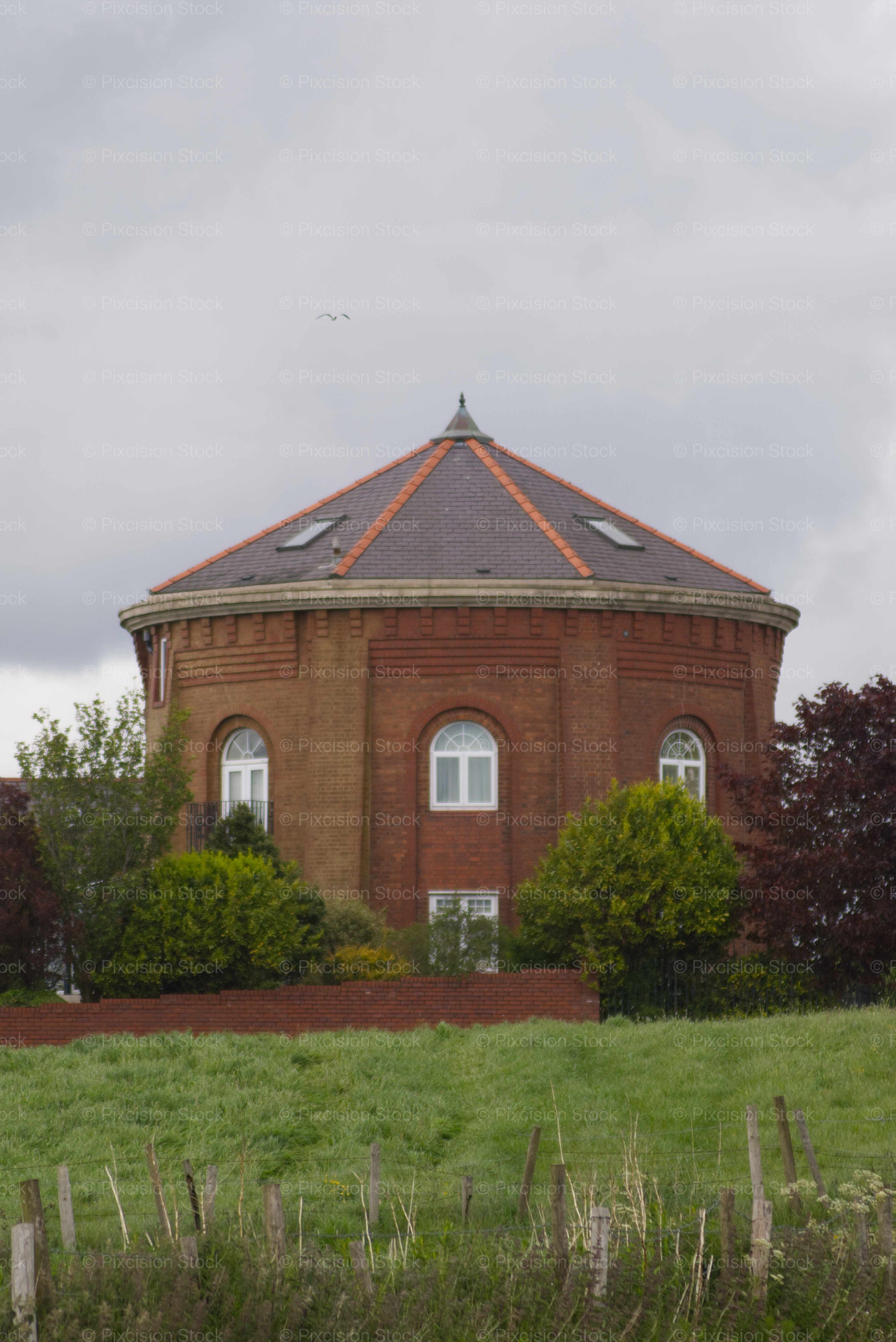 Red brick building with a triangular roof in a rural setting