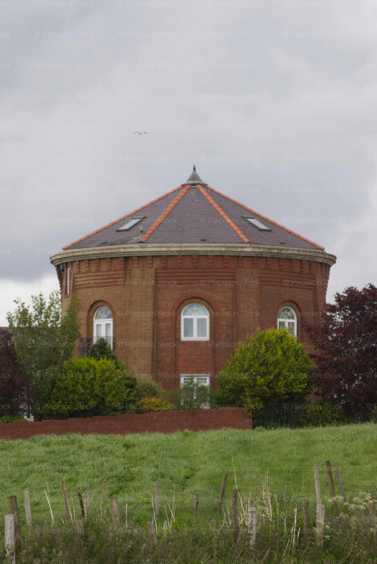 Red brick building with a triangular roof in a rural setting