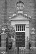 Front Entrance Facade of a Historic Brick Building with a Pediment (Monochrome)