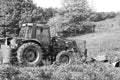 Farm Tractor Parked in a Grassy Field Near Trees (Monochrome)