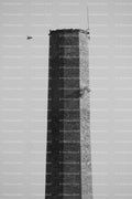 Close-Up of the Top of an Industrial Brick Chimney Against the Sky (Monochrome)