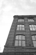 Low-Angle Shot Looking Up at the Facade of a Historic Brick Factory (Monochrome)