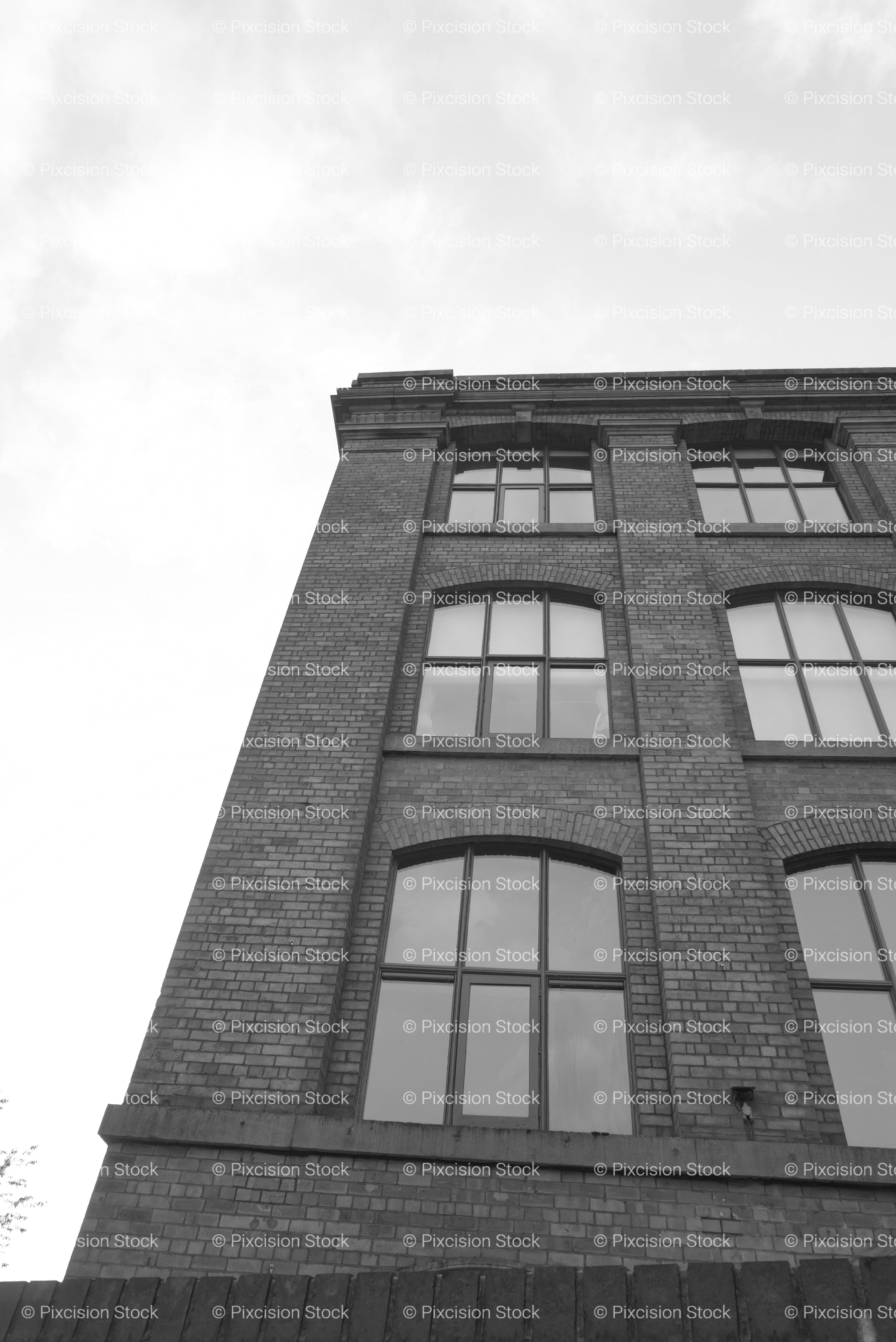Low-Angle Shot Looking Up at the Facade of a Historic Brick Factory (Monochrome)