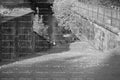 Shaded Stone Pathway Running Along a Brick Retaining Wall (Monochrome)
