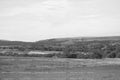 Open Rural Field Leading Towards Distant Hills (Monochrome)