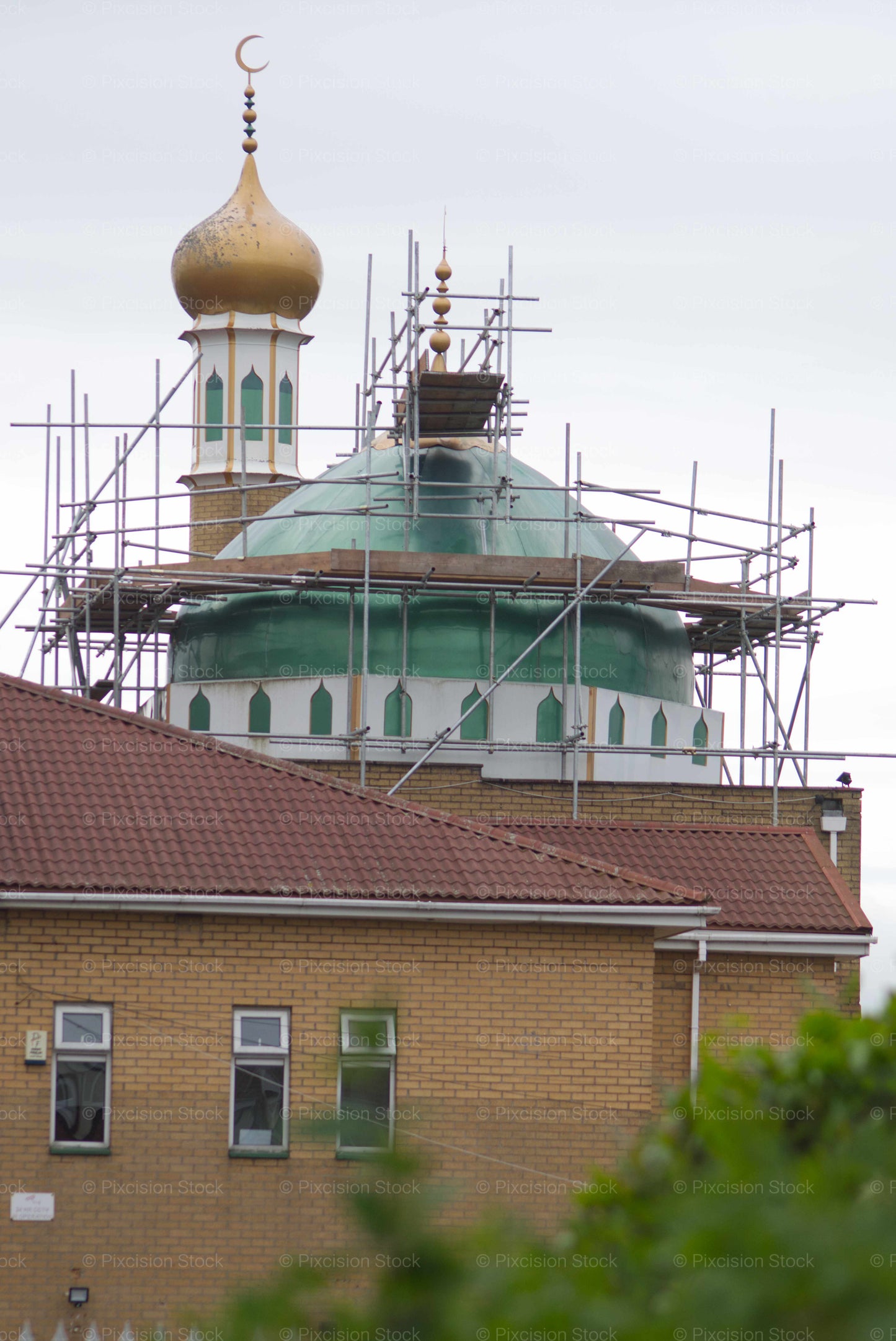 Mosque with a dome and minaret under scaffolding