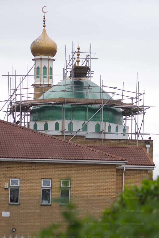 Mosque with a dome and minaret under scaffolding