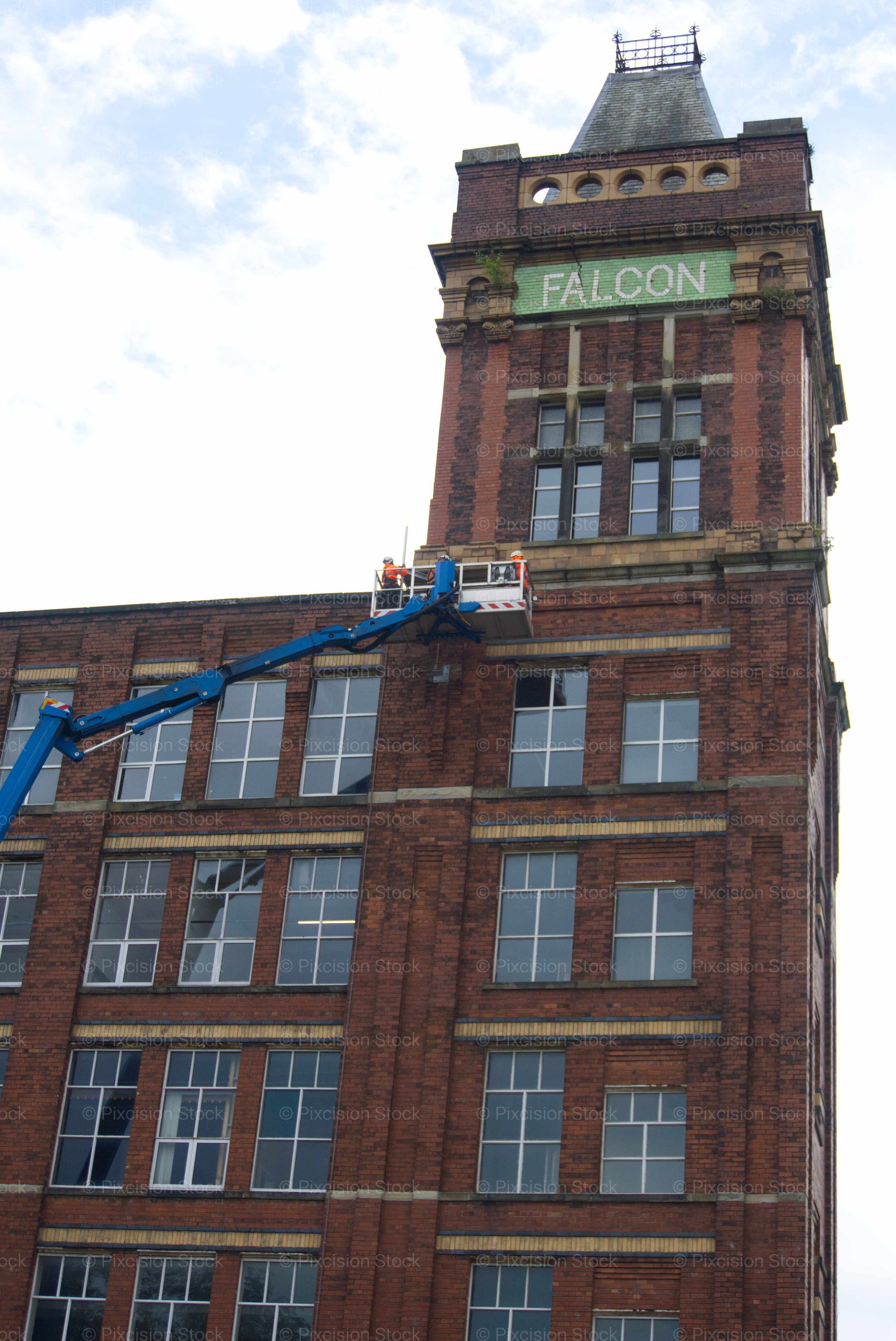 Brick building with 'Falcon' sign and blue crane