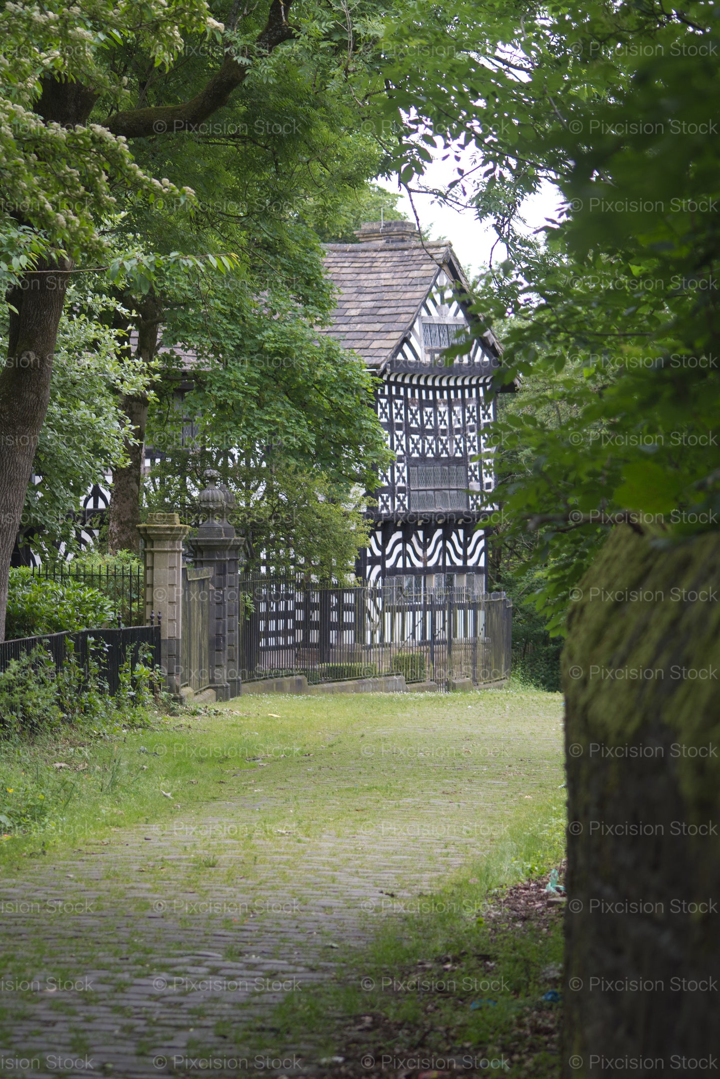 Traditional black and white Tudor timbered building in a garden setting
