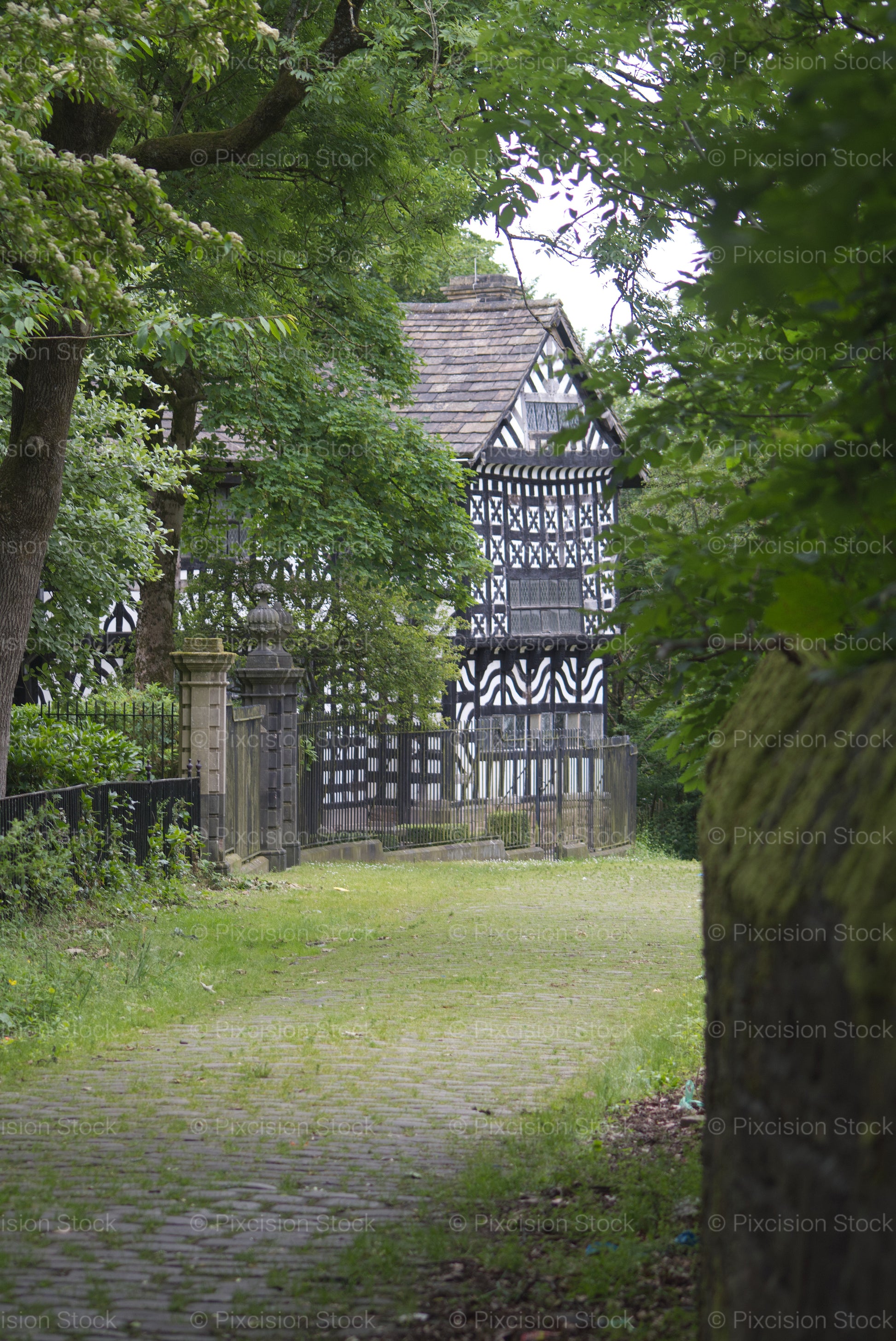 Traditional black and white Tudor timbered building in a garden setting