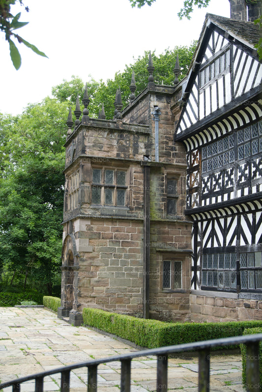 Historic building with stone and timber architecture, surrounded by greenery.
