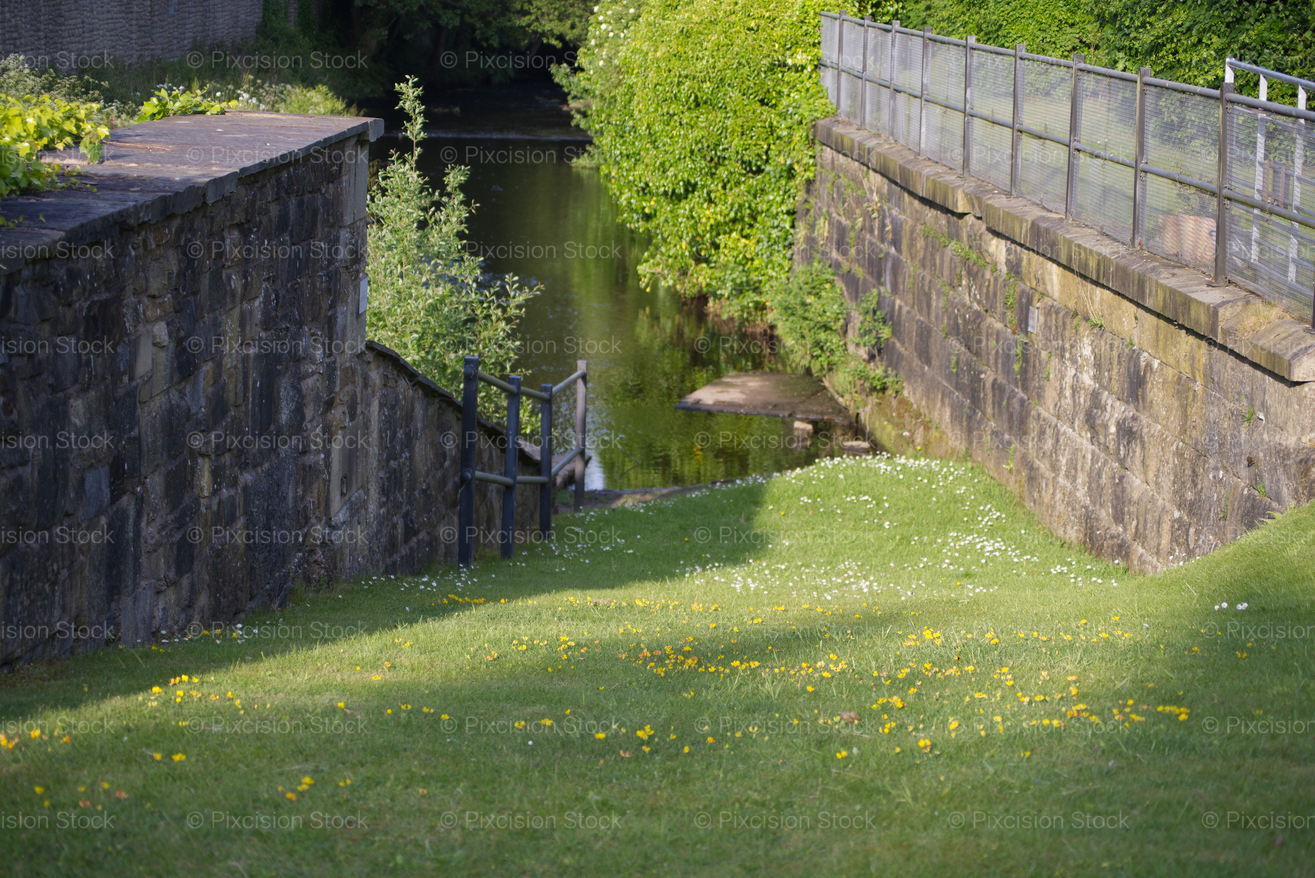 Shaded Stone Pathway Running Along a Brick Retaining Wall